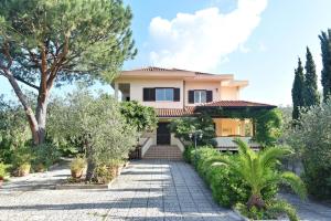 ein Haus mit einem Garten und einer Auffahrt in der Unterkunft Villa Tina in Santa Maria di Castellabate