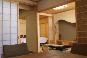 una stanza con tavolo e una camera da letto di Hanaichi a Tsumagoi