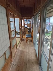 un pasillo de una casa con suelo y ventanas de madera en Huuran, en Nakijin