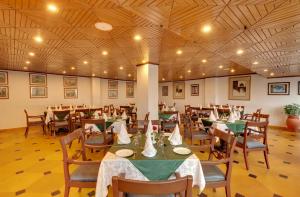 a dining room with tables and chairs in it at Hotel Combermere in Shimla