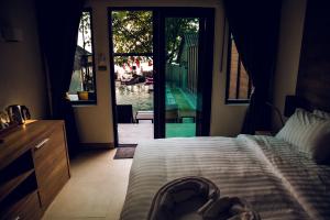 a bedroom with a bed and a sliding glass door at 15 Palms Beach Resort in Ko Chang