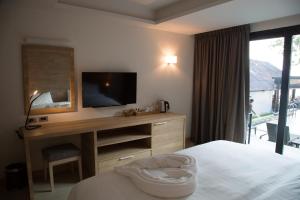 a bedroom with a bed and a desk with a television at 15 Palms Beach Resort in Ko Chang