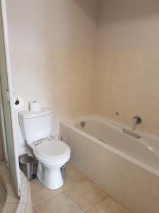 a bathroom with a toilet and a bath tub at The Island Club Apartment in Cape Town +10 photos