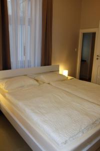 a bed with white sheets and pillows in a bedroom at Stars Berlin Apartments Essener Straße in Berlin