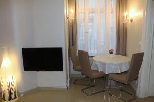 een eetkamer met een tafel met stoelen en een televisie bij Stars Berlin Apartments Essener Straße in Berlijn