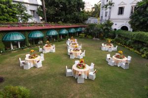 un groupe de tables avec des fleurs dans une cour dans l'établissement Kenilworth Hotel, Kolkata, à Kolkata