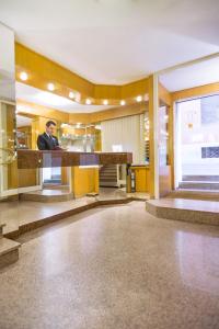 a man sitting at a counter in a lobby at Best Western Hotel Libertà in Modena