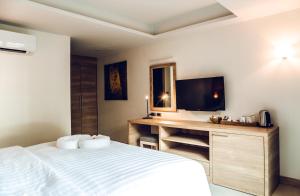 a bedroom with a bed and a desk with a television at 15 Palms Beach Resort in Ko Chang