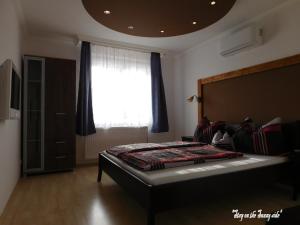 A bed or beds in a room at Sunrise Apartmanház