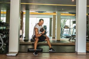 a man sitting on a bench in a gym at AtEase Phuket Patong in Patong Beach