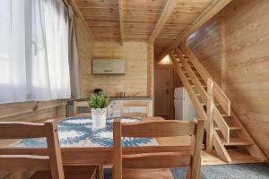 ein Esszimmer mit einem Tisch und Stühlen in einer Hütte in der Unterkunft Biała Wioska 1 in Ustronie Morskie