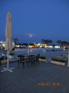 a group of chairs and an umbrella next to a pool at Kokalakis Hotel in Kefalos