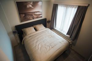 een slaapkamer met een bed en een groot raam bij O-Mer Oostende in Oostende