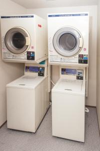 2 Waschmaschinen sowie eine Waschmaschine und ein Trockner in einem Zimmer in der Unterkunft Guest House Nakaima in Fukuoka