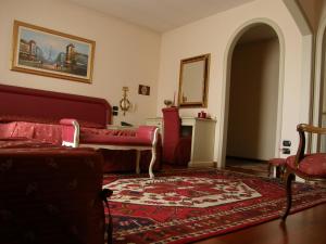 a living room with a red couch and a rug at Residence Meuble' Cortina in Quinto di Treviso