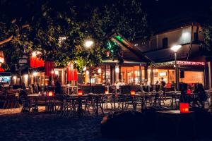 a restaurant with tables and chairs at night at 15 Palms Beach Resort in Ko Chang