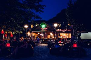 a group of people sitting in front of a restaurant at night at 15 Palms Beach Resort in Ko Chang