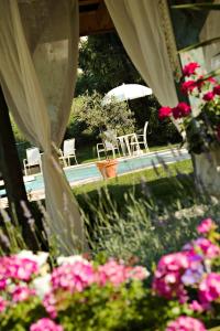 a view of a garden with pink flowers and an umbrella at Logis Auberge Saint Simond in Aix-les-Bains