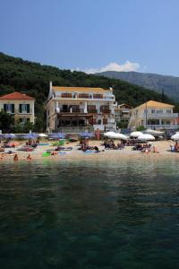 a group of people on a beach with umbrellas at Villa Coralli in Parga