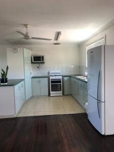 a kitchen with white cabinets and a refrigerator at Best Beach Villa in Denham