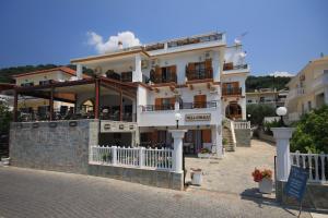 a large white building with a balcony on a street at Villa Coralli in Parga