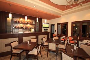 a restaurant with tables and chairs and a bar at Villa Coralli in Parga