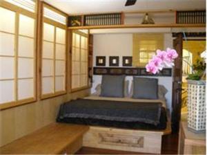 a bedroom with a bed in a room with windows at Secret Garden Inn in San Diego