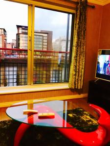 Glasgow City Centre Flat with River Views and Parking في غلاسكو: غرفة معيشة مع طاولة زجاجية ونافذة