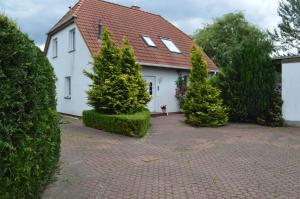 a white house with trees in front of it at Twee Linden Nienhagen in Ostseebad Nienhagen