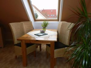 a wooden table with two chairs and a plant at Twee Linden Nienhagen in Ostseebad Nienhagen +18 photos
