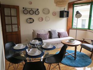 a living room with a couch and a table and chairs at Porto 1 Bedroom Beach Apartment in Matosinhos