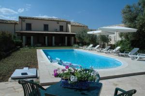 a swimming pool with chairs and a table with flowers at San Domenico Residence in Arenella