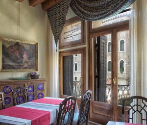 a dining room with a table and a window at B&B San Firmino in Venice
