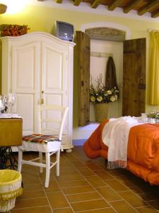 a bedroom with a bed and a chair in a room at Locanda Zacco in Marliana