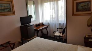 a bedroom with a desk with a computer and a window at Hotel Royal in Alessandria