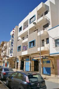 a building with cars parked in front of it at Résidence Rive D'or in Martil