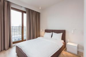 a bedroom with a large bed with a large window at Platinum Residence Mokotów in Warsaw