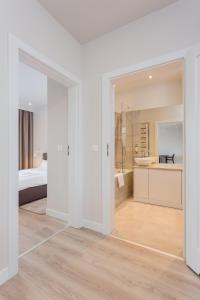 a white room with a bed and a bathroom at Platinum Residence Mokotów in Warsaw