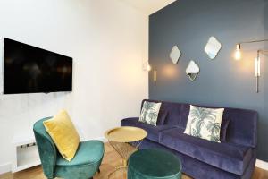 - un salon avec un canapé violet et deux chaises dans l'établissement Rent a Room - Charon 3, à Paris