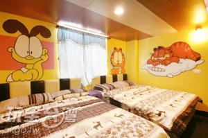 two beds in a room with cartoons on the walls at Her Home Homestay in Green Island