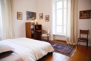 1 dormitorio con cama, escritorio y ventana en Château de Penfrat, en Gouesnach