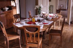 a wooden dining room table with chairs and a tableablish at Château de Penfrat in Gouesnach