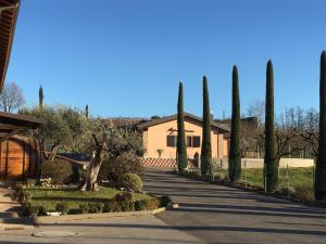 a house with a row of trees on a street at La Corte D'Emilio B&B in Vignola