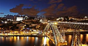 a bridge over a river with a city at night at Porto Bridges By Living Well in Vila Nova de Gaia