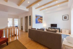 a living room with a couch and a television at Porto Bridges By Living Well in Vila Nova de Gaia