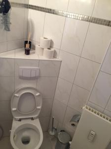 ein Badezimmer mit einem WC und einem Regal mit Toilettenpapier in der Unterkunft Lister platz Apartment in Hannover