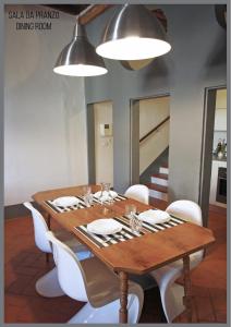 comedor con mesa de madera y sillas blancas en Appartamento Il Fregio, en Pistoia