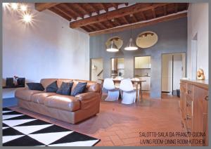 sala de estar con sofá de cuero marrón y mesa en Appartamento Il Fregio, en Pistoia
