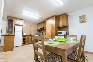 a kitchen and dining room with a wooden table and chairs at Recanto dos Sonhos in Cinco Ribeiras