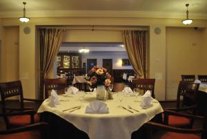 a dining room with a table with a vase of flowers at Girele in Šiauliai